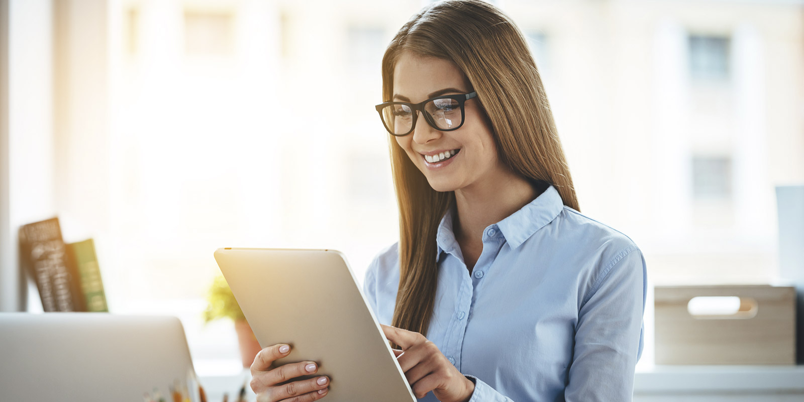 Eine Buerofrau die ein Tablet bedient